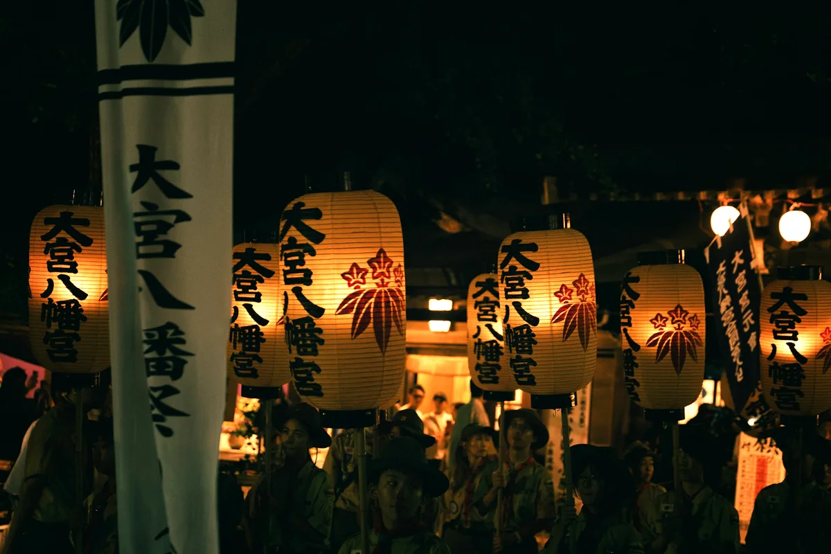 Glowing paper lanterns strung above a Japanese night festival