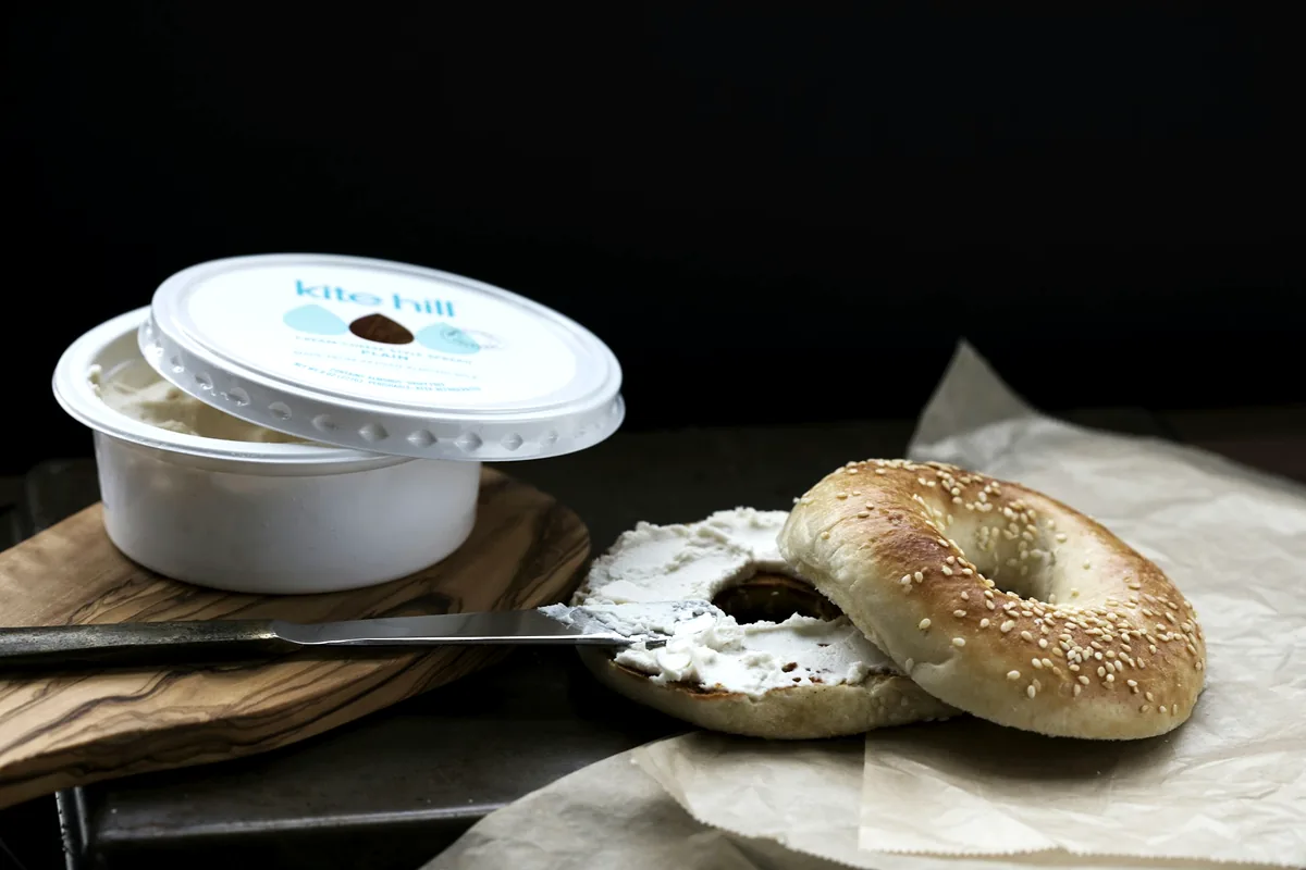 A bowl of soft white cream cheese with a knife resting in it