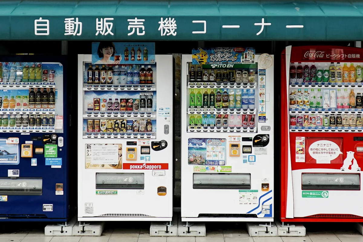 A row of Japanese drink vending machines lit up on a street