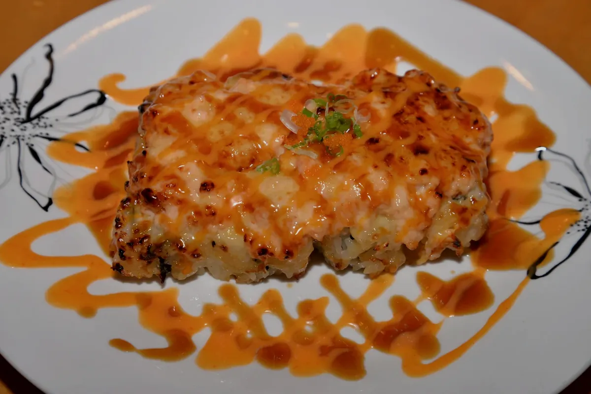 Baked Salmon roll with baked salmon spread over a California roll