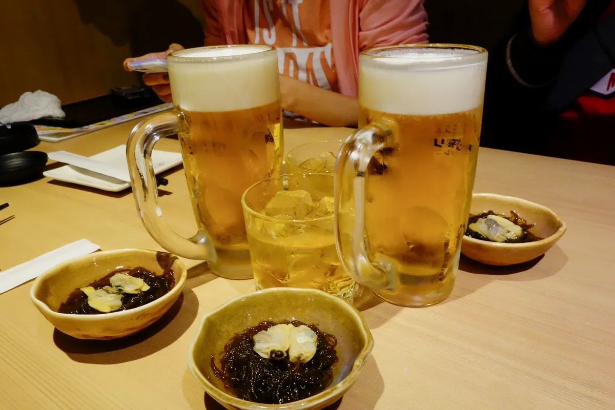 Glasses of beer on a table with several small side dishes