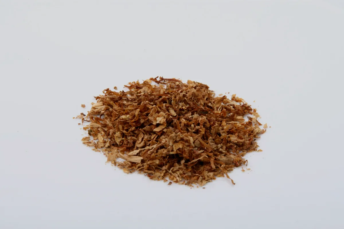 A pile of fine pink-brown dried bonito flakes on a white surface
