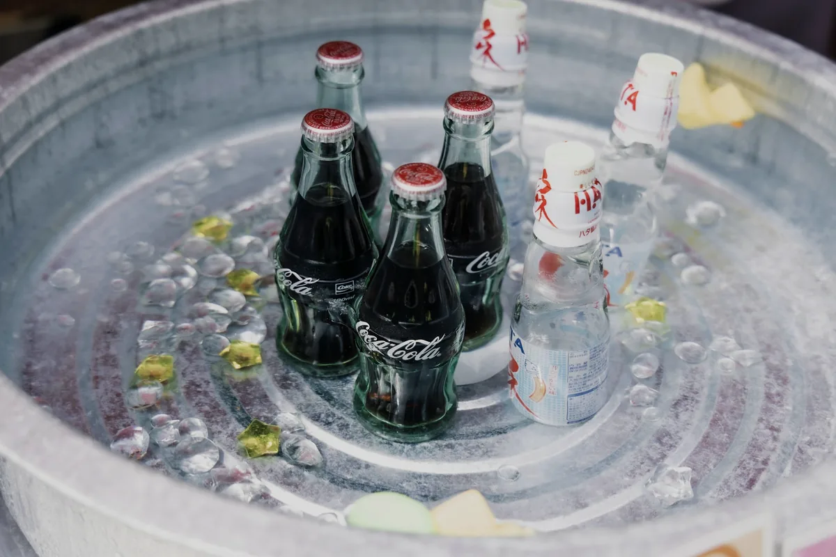 Glass soda bottles chilling in a tub of ice water