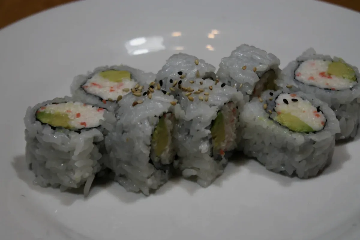California Roll cut into eight pieces on a white plate