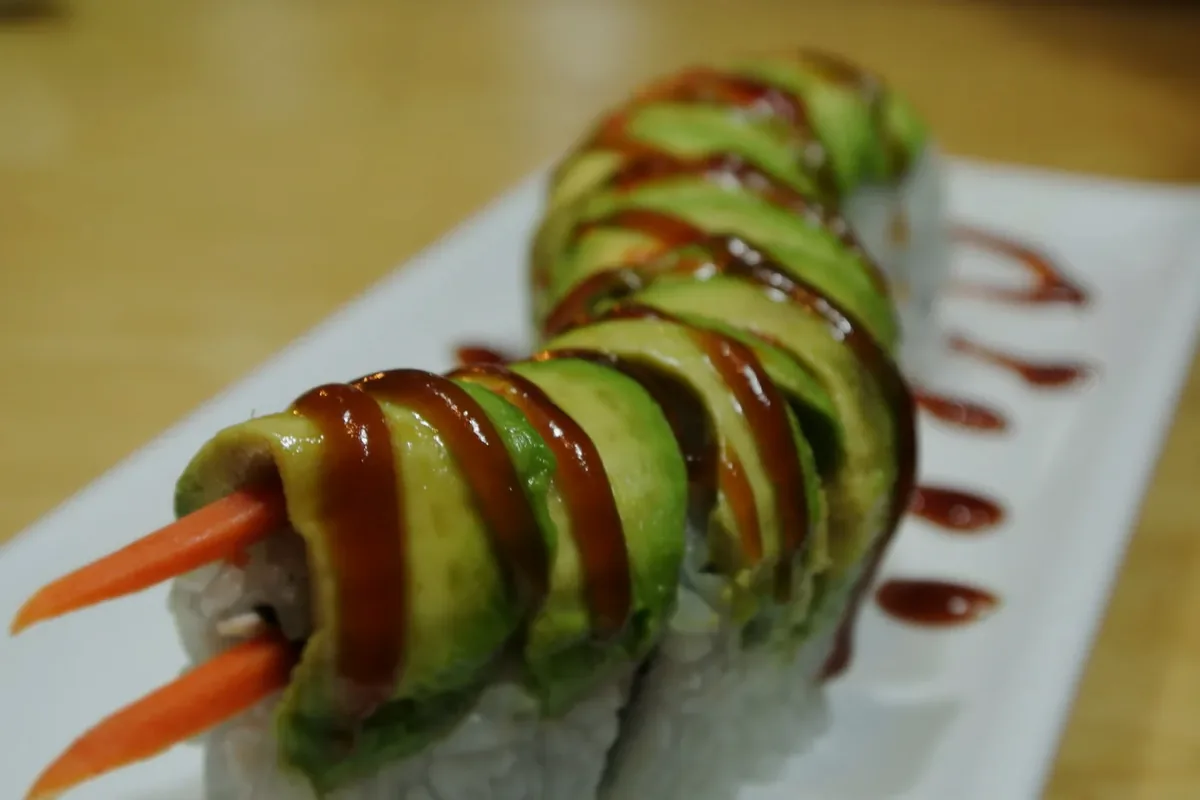 Caterpillar roll with eel and crabmeat, covered in overlapping avocado slices