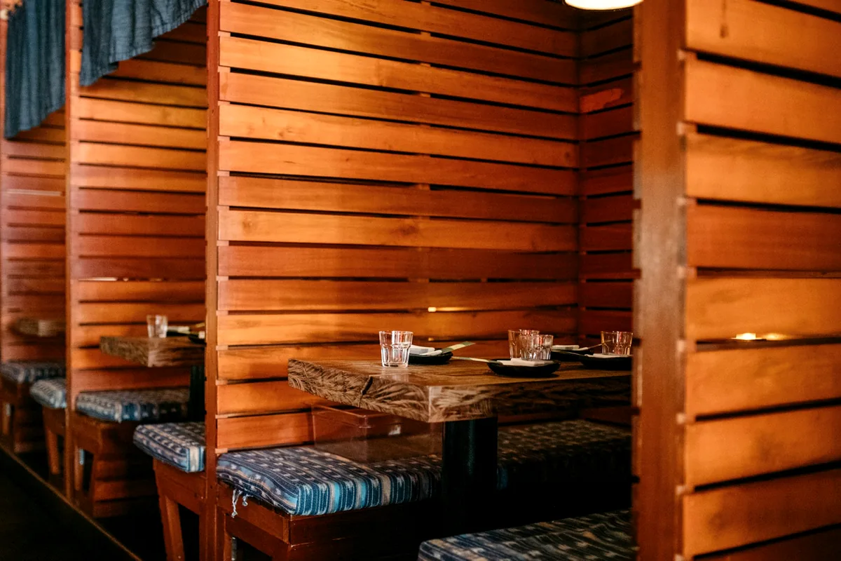 An empty restaurant counter set with plates and chopsticks