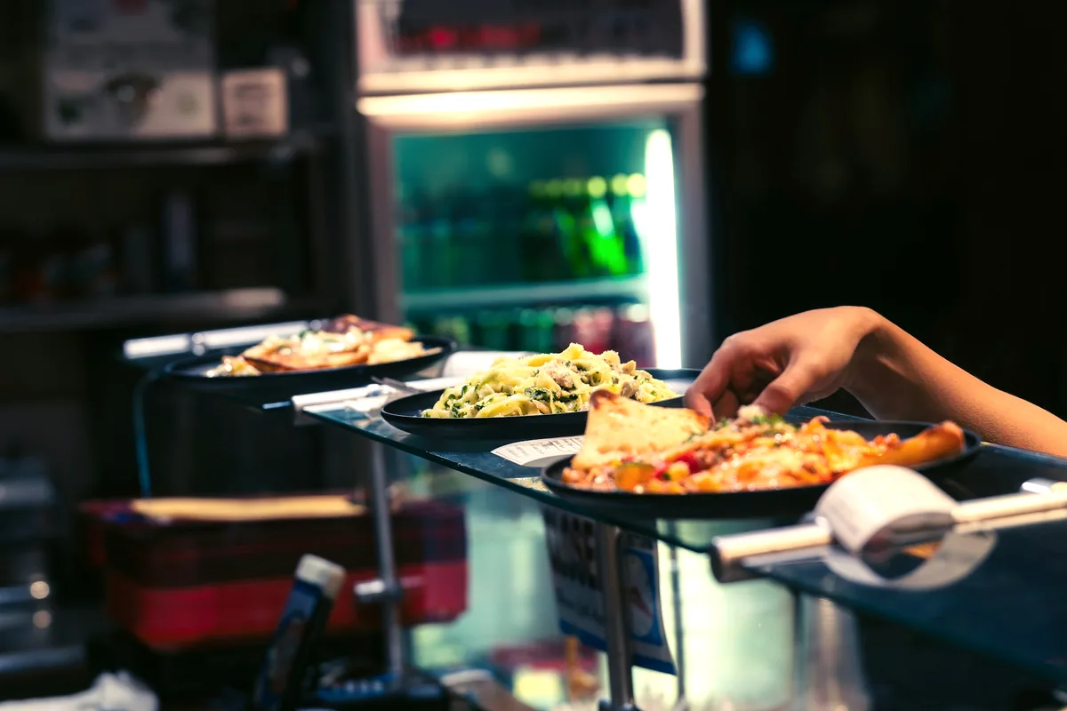 Food being passed across a service counter to a waiting diner