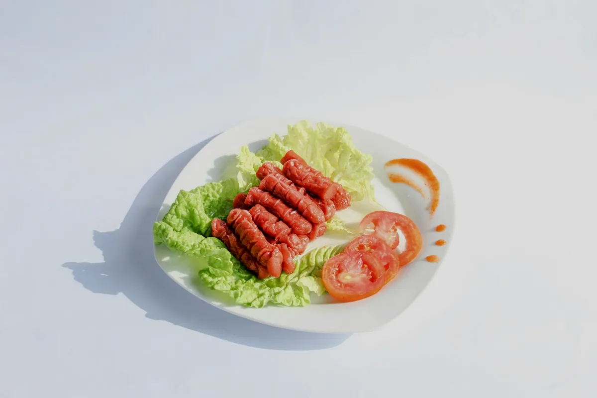 A close view of red and white imitation crab sticks on lettuce