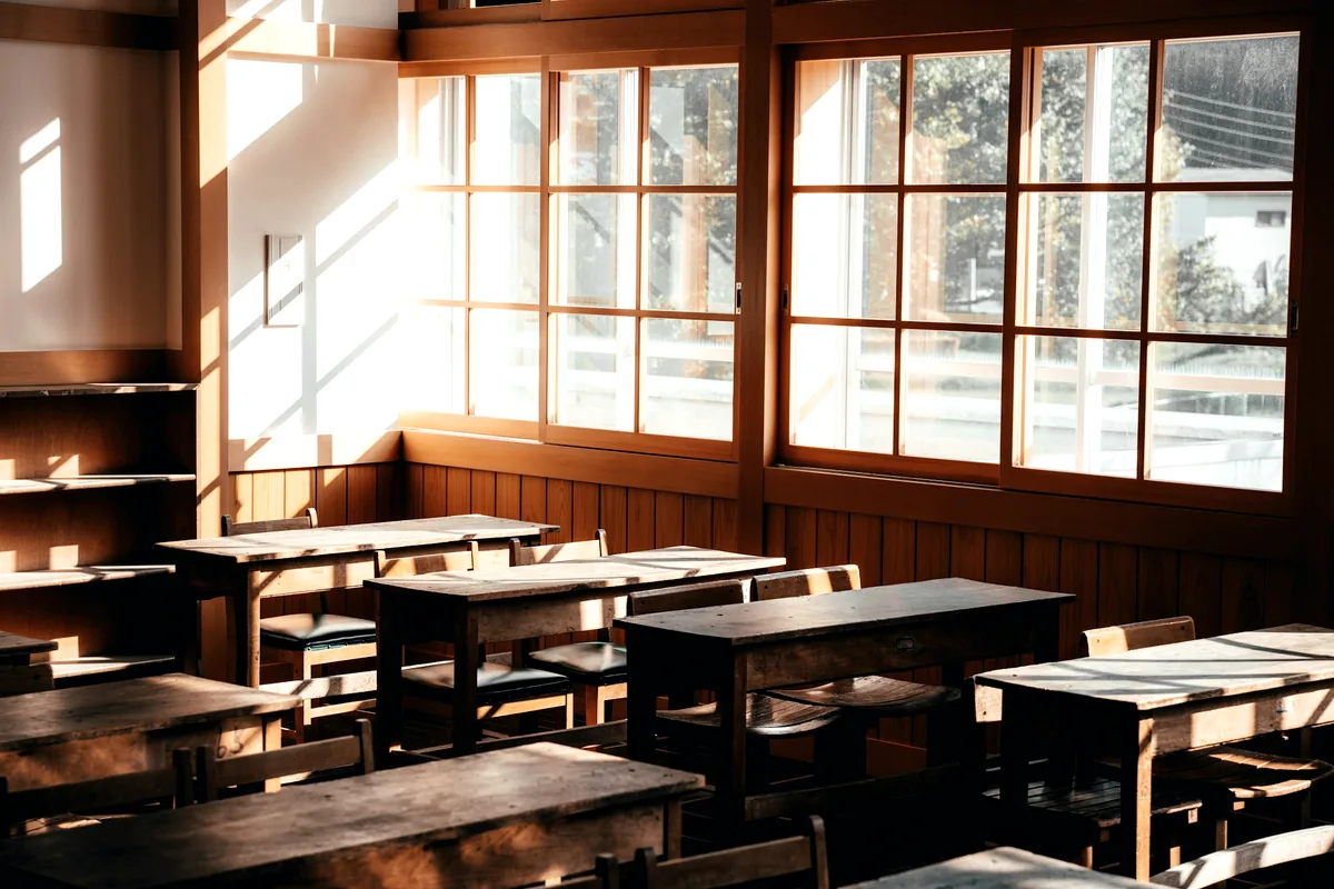 An empty restaurant dining room lit by large windows during the day