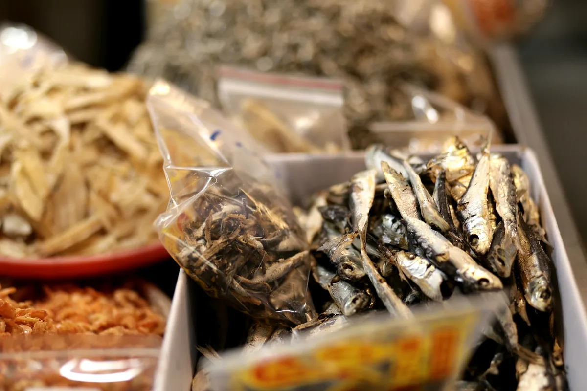 Trays of small dried fish and seafood at a market