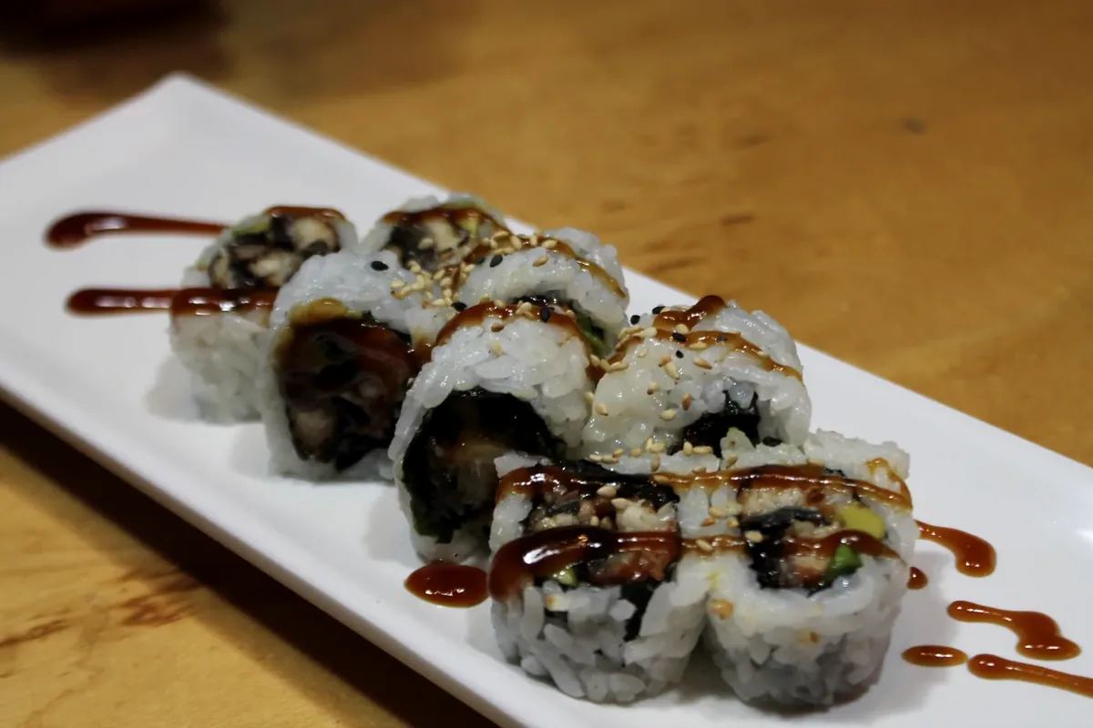 Eel Roll cut into pieces and finished with a dark glaze and sesame