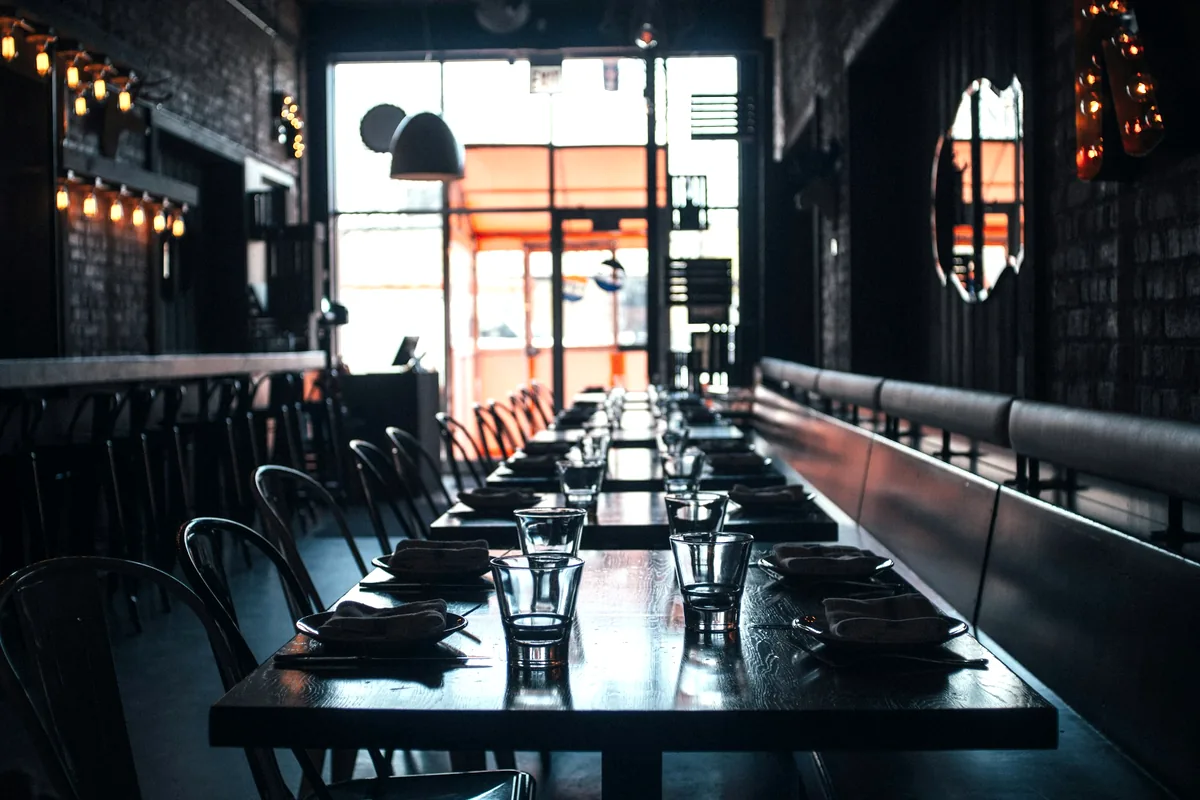 A long empty restaurant counter with stools before service