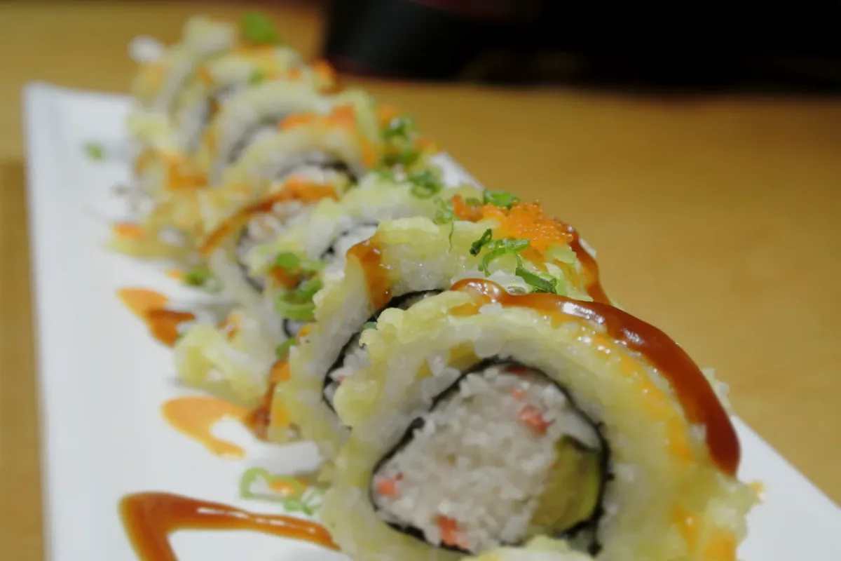 Golden California, a deep fried California roll, sliced and drizzled with sauce