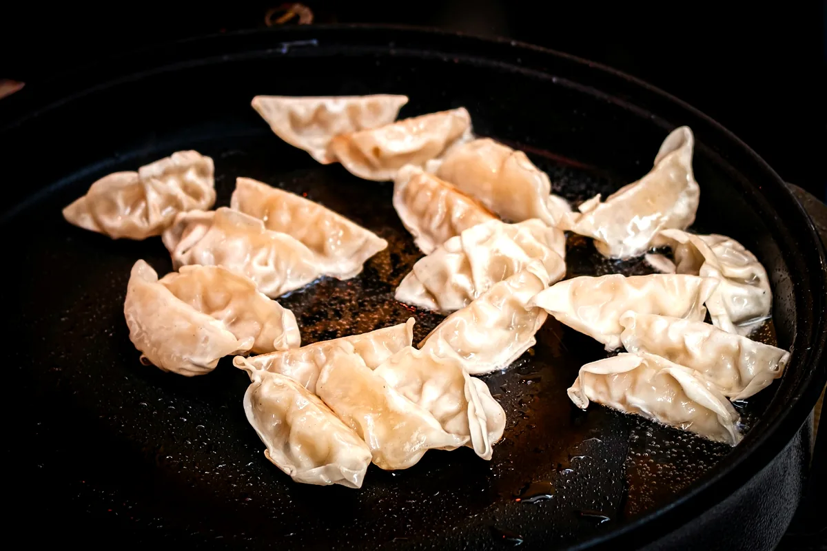 Pleated raw dumplings laid out before cooking