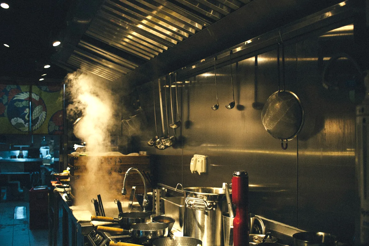 Steam rising over the pass in a busy commercial kitchen