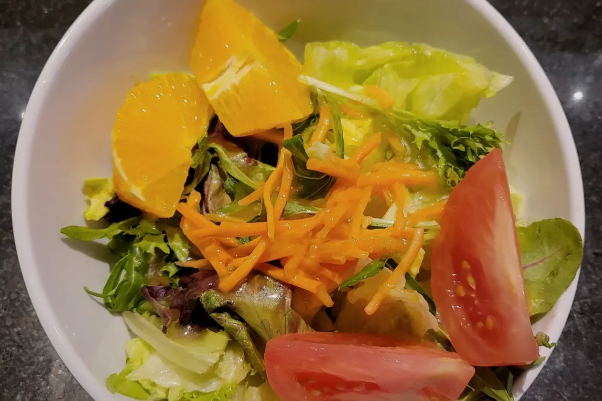 House Salad with mixed greens, tomato, orange and shredded carrot