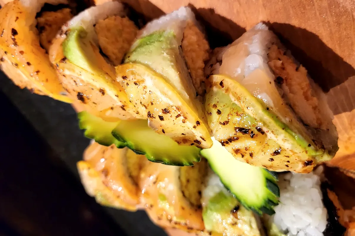Lemon Flush, spicy crab and avocado with salmon and lemon laid over the top