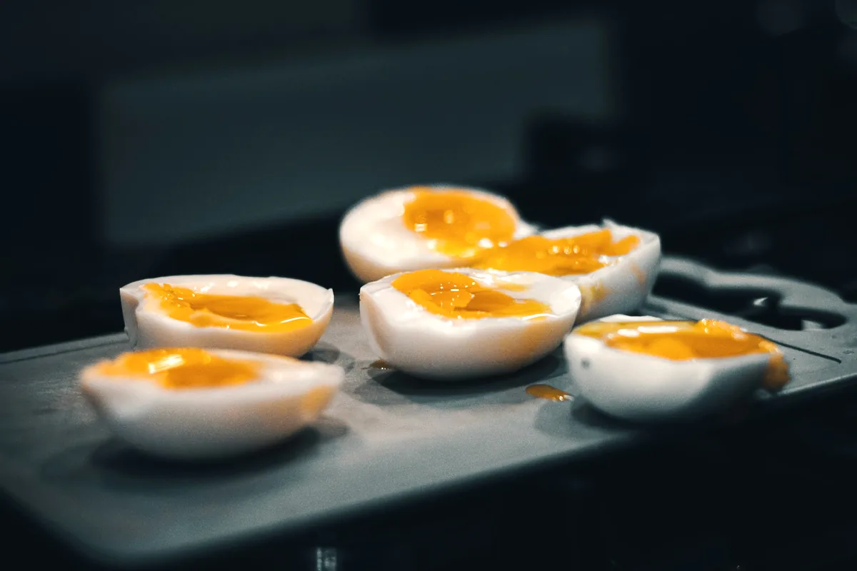 Several soft boiled eggs halved to show the marinated jammy yolks