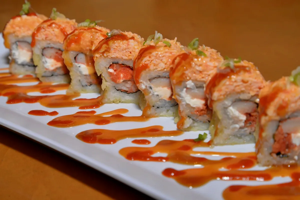 Monster roll, spicy crab over a deep fried spicy tuna, cream cheese and crab roll