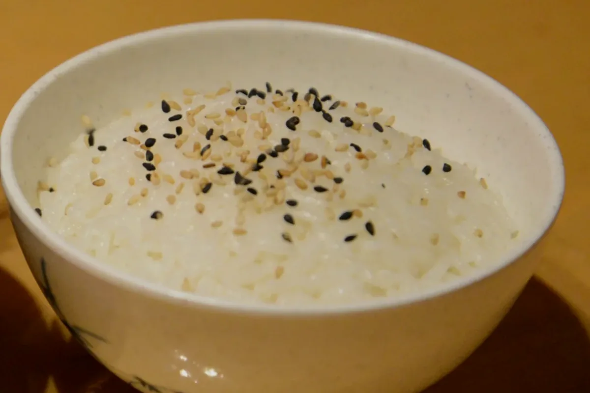 A bowl of steamed rice sprinkled with black sesame