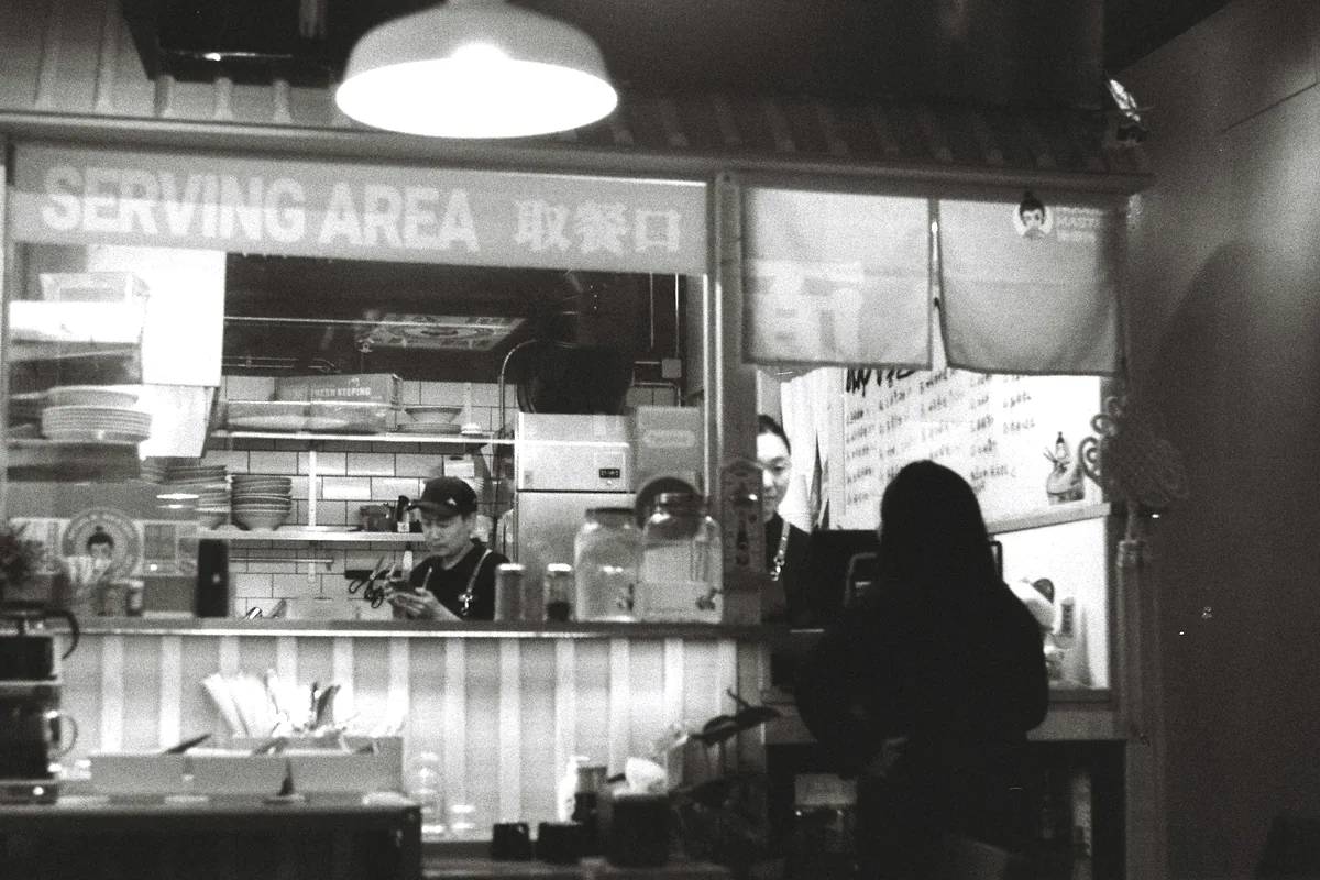 A black and white view of a small restaurant serving area