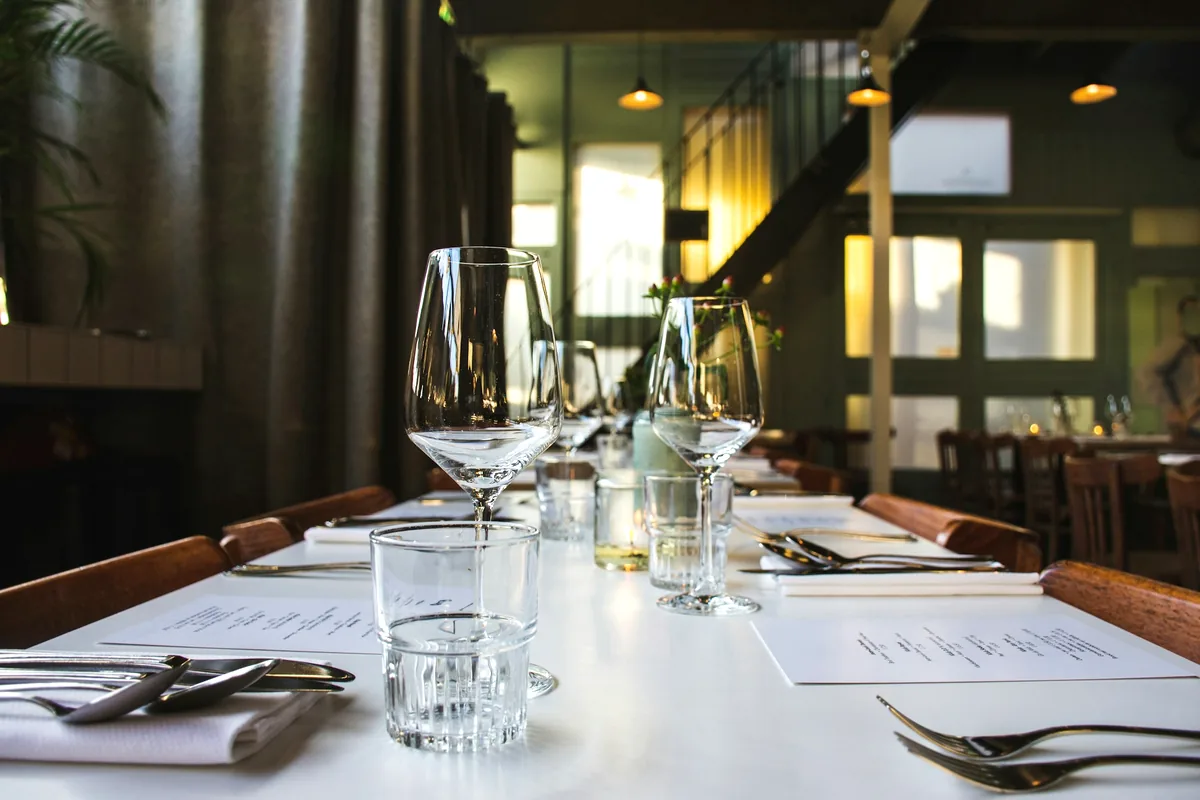 Two place settings with glassware on a linen-covered table