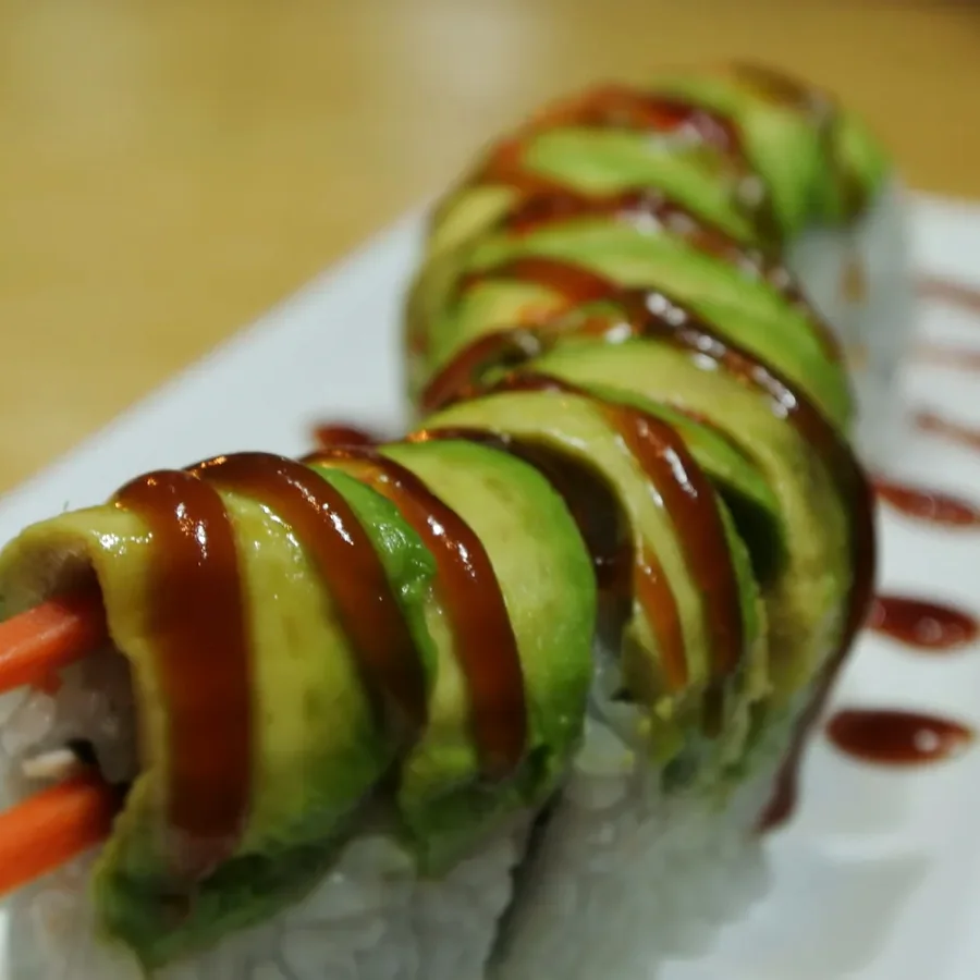 Caterpillar roll under overlapping slices of avocado