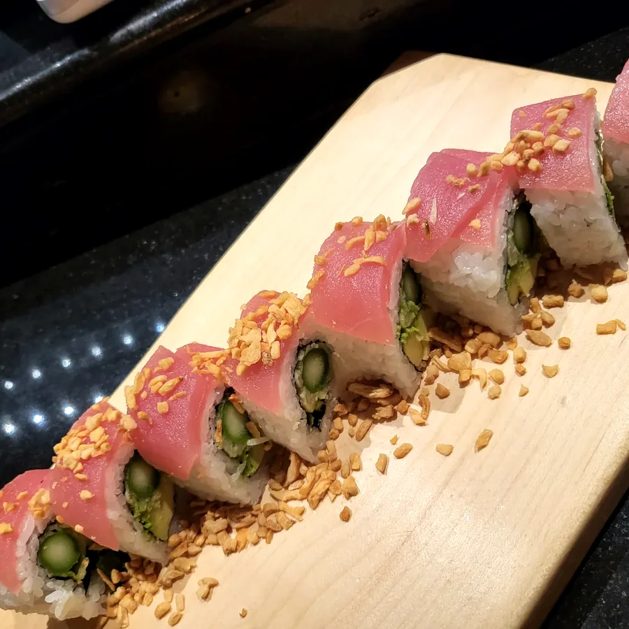 Fisherman's roll topped with tuna and sesame on a maple board