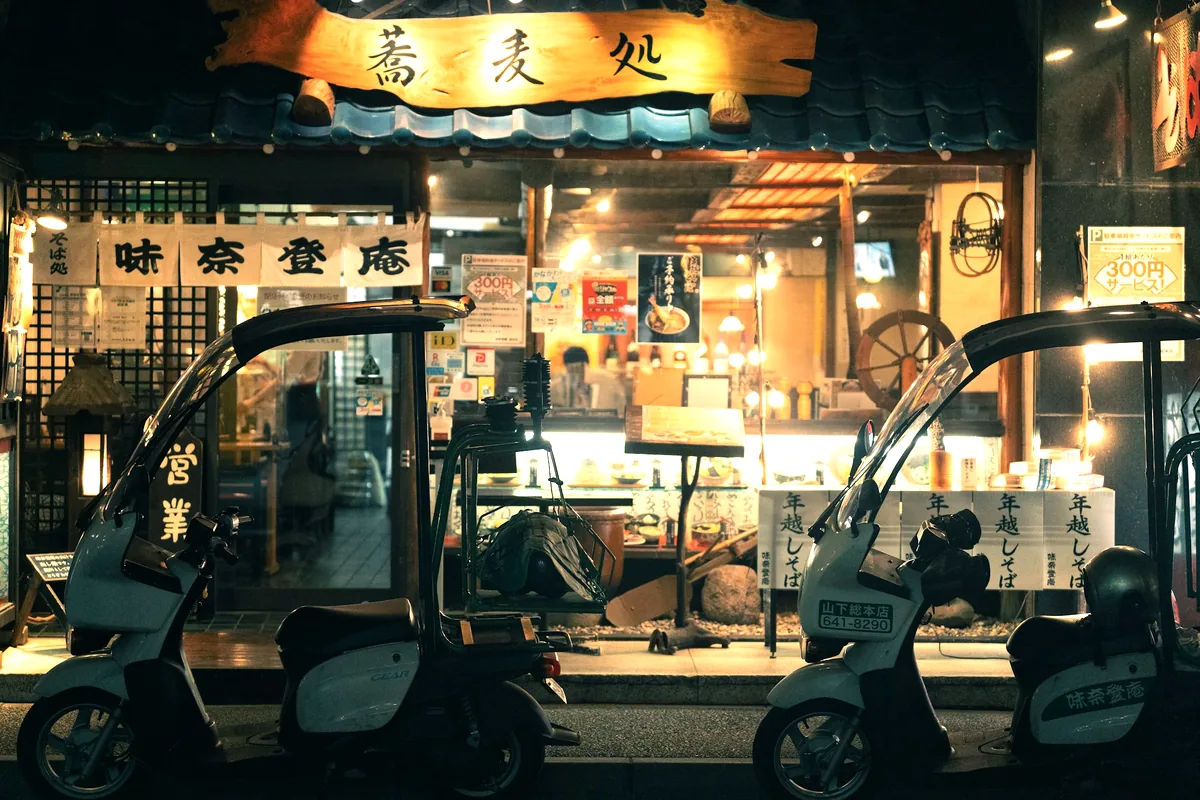 The lit frontage of a small Japanese noodle shop in the evening