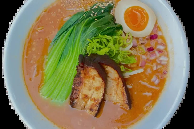 Spicy Miso Ramen with braised pork belly, bok choy, a halved soft egg and red onion
