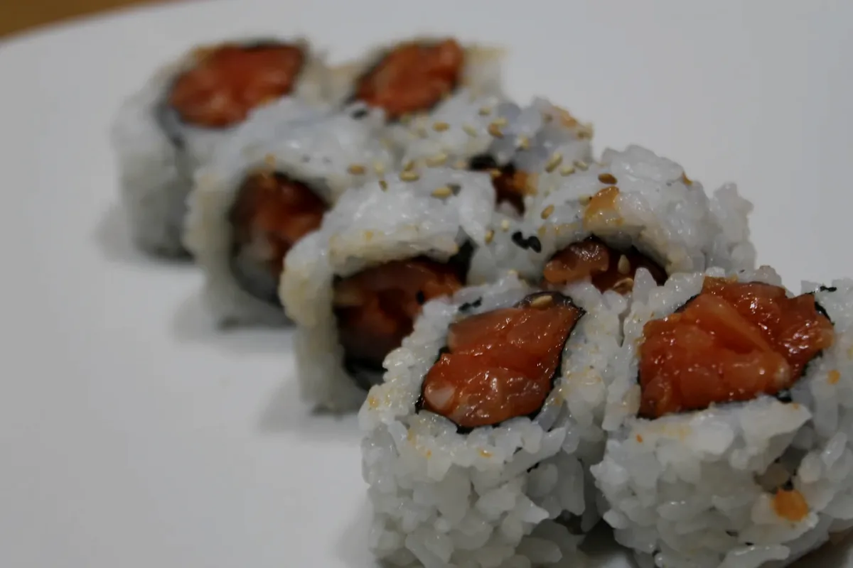 Spicy Salmon Roll cut into pieces, nori visible around the outside