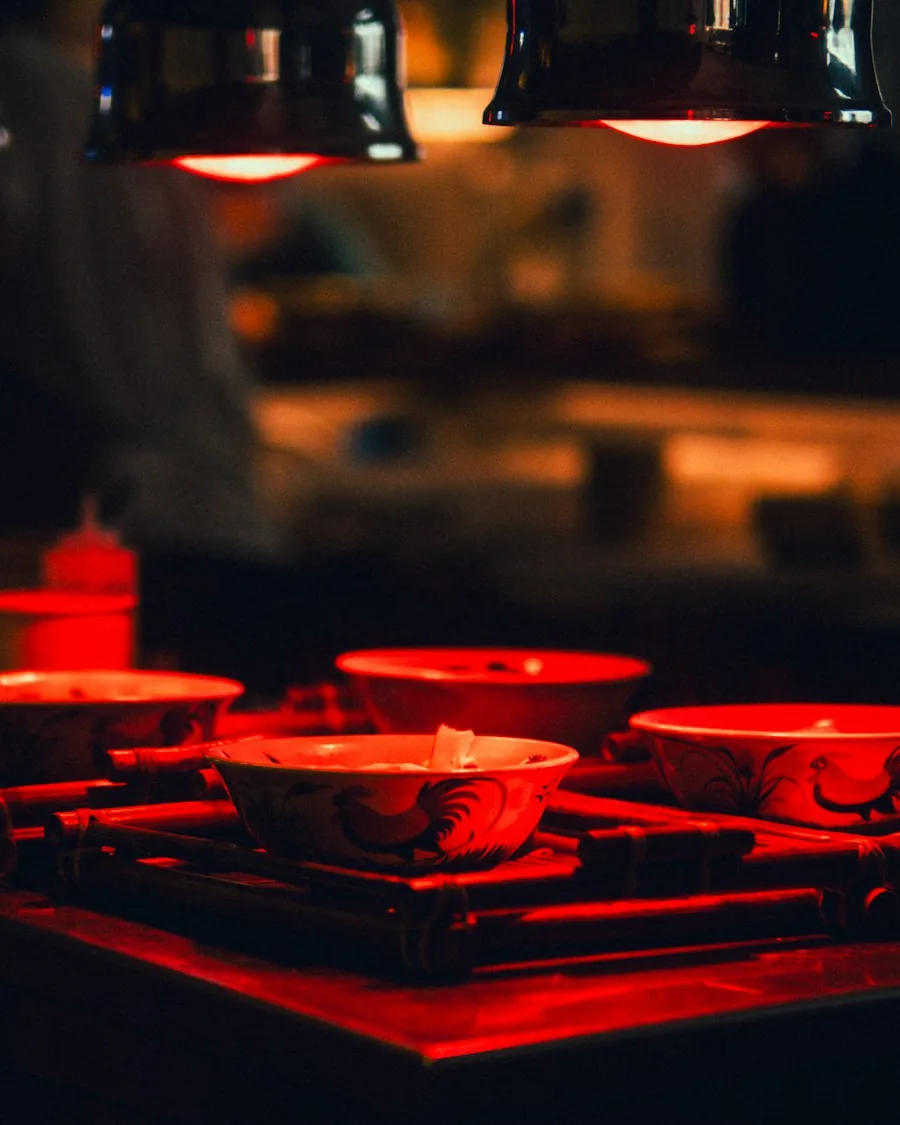 Bowls waiting under the red heat lamps of a restaurant pass