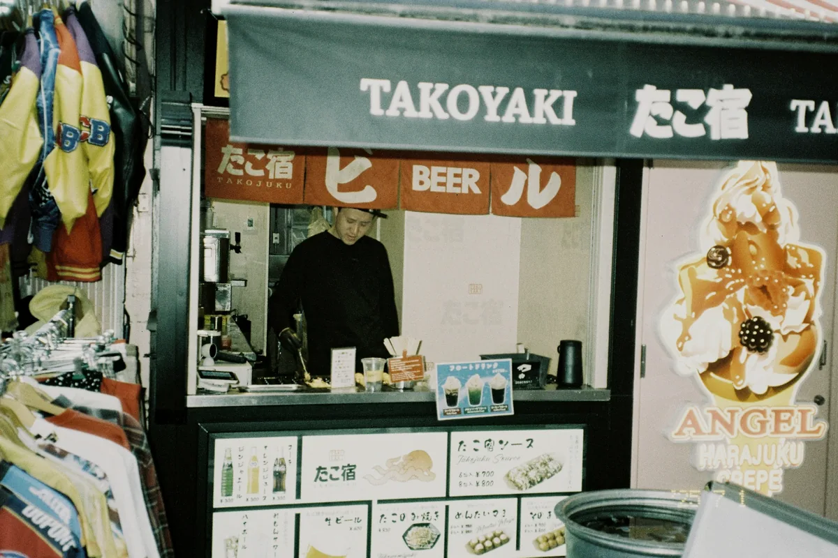 A small takoyaki shop with signage and a counter