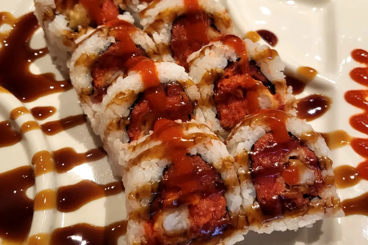 Tiger roll made with spicy tuna and shrimp tempura, finished with sauce