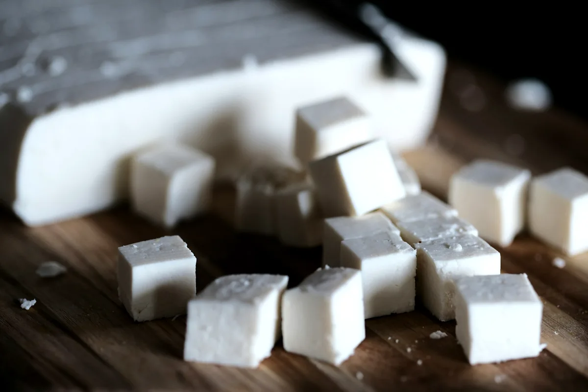 Cubes of fresh white tofu on a wooden board