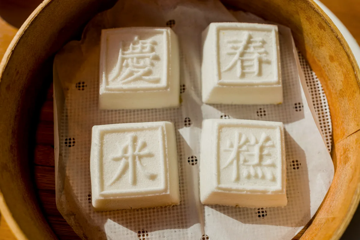 Blocks of tofu stamped with characters in a bamboo steamer