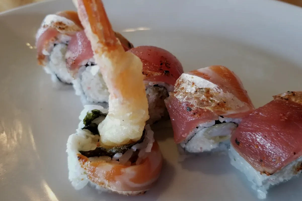 Tokyo 6 with shrimp tempura and crabmeat, topped with cajun salmon and tuna