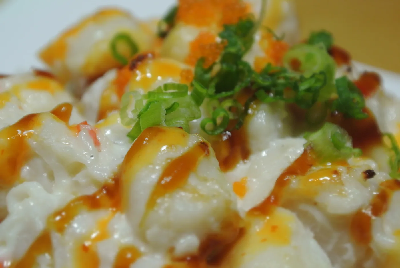 Baked Scallop roll under a browned scallop topping with green onion