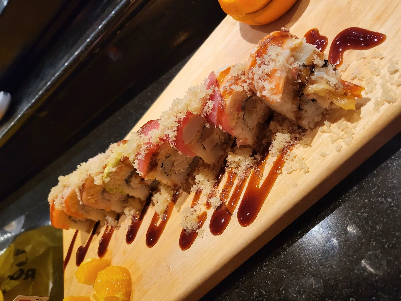 Crunch Rainbow roll topped with sliced fish and tempura crunch