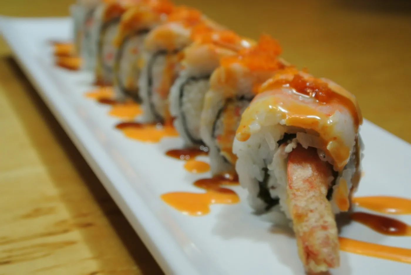 Double Dragon roll under overlapping avocado with eel sauce