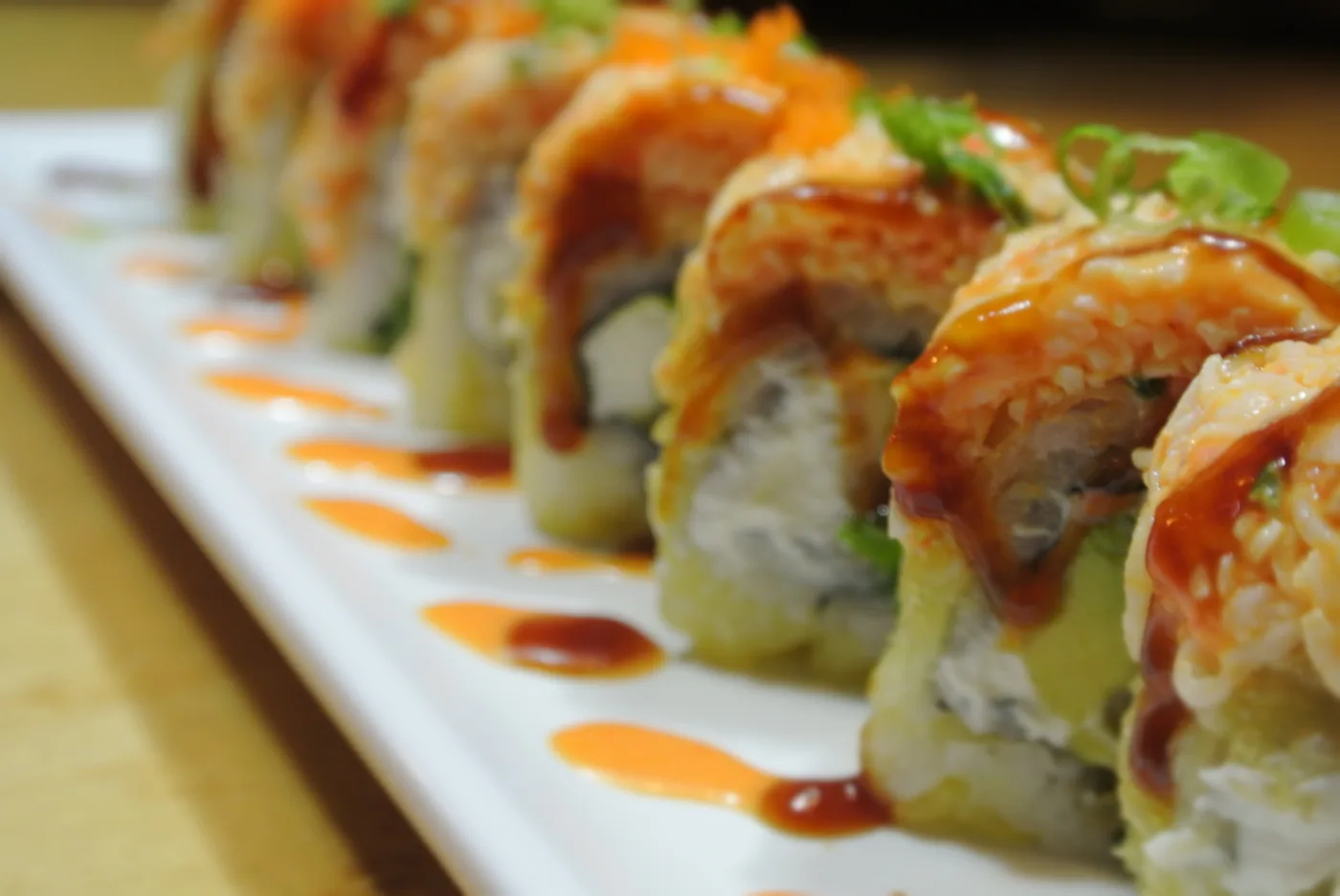 Golden Tiger roll with spicy crab over a fried shrimp tempura and cream cheese roll