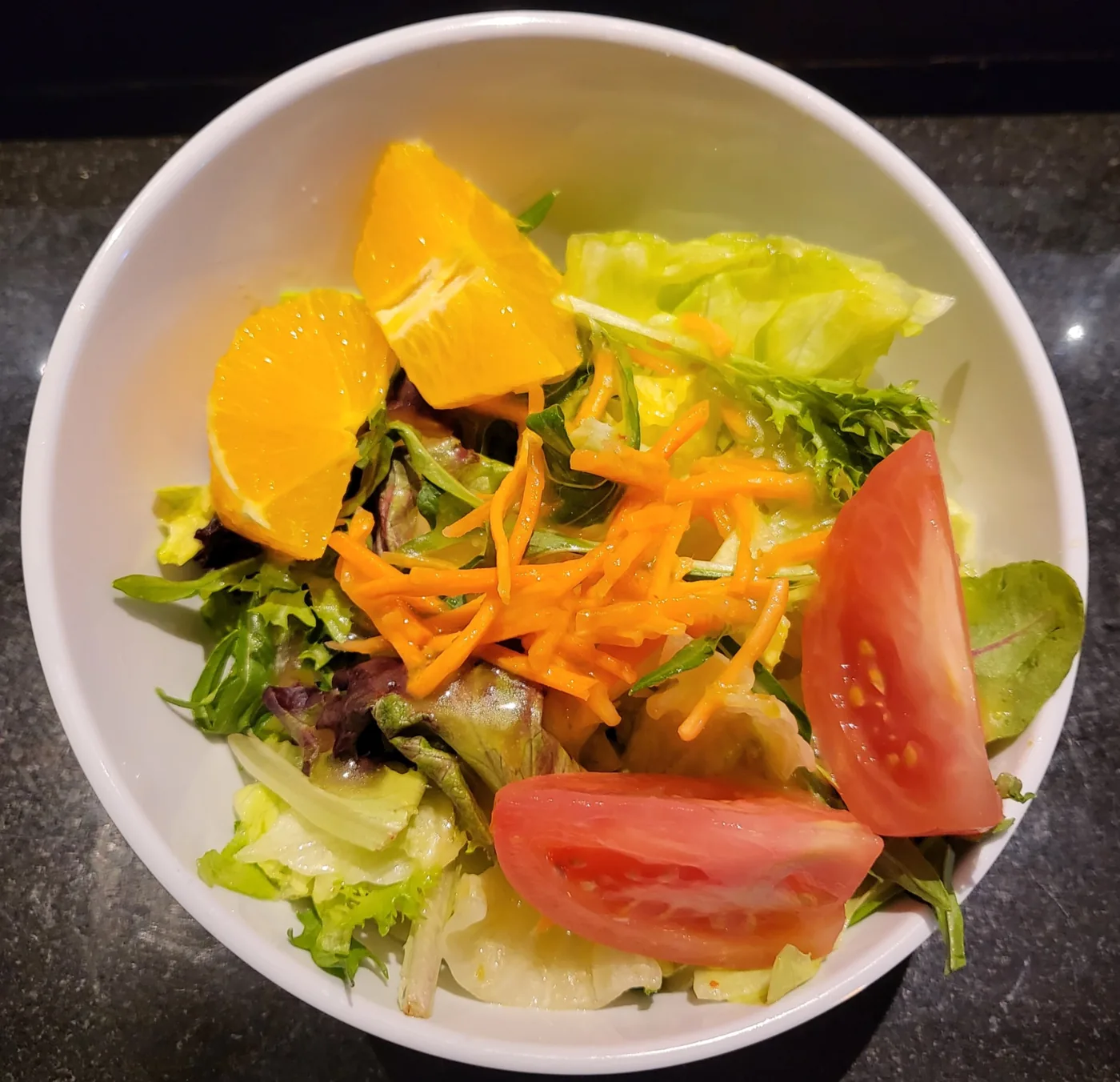 House Salad in a white bowl with tomato, carrot and orange segments