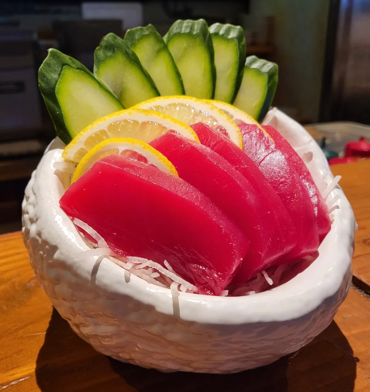 An individual five-piece sashimi order of sliced tuna in a white bowl