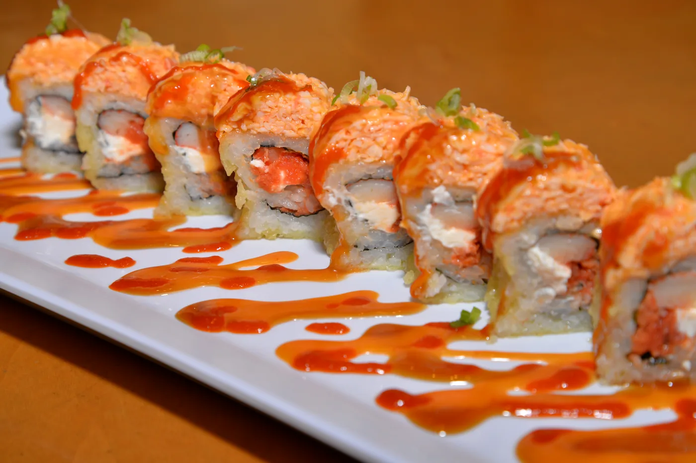 Monster roll - spicy crab over a deep fried spicy tuna, cream cheese and crab roll