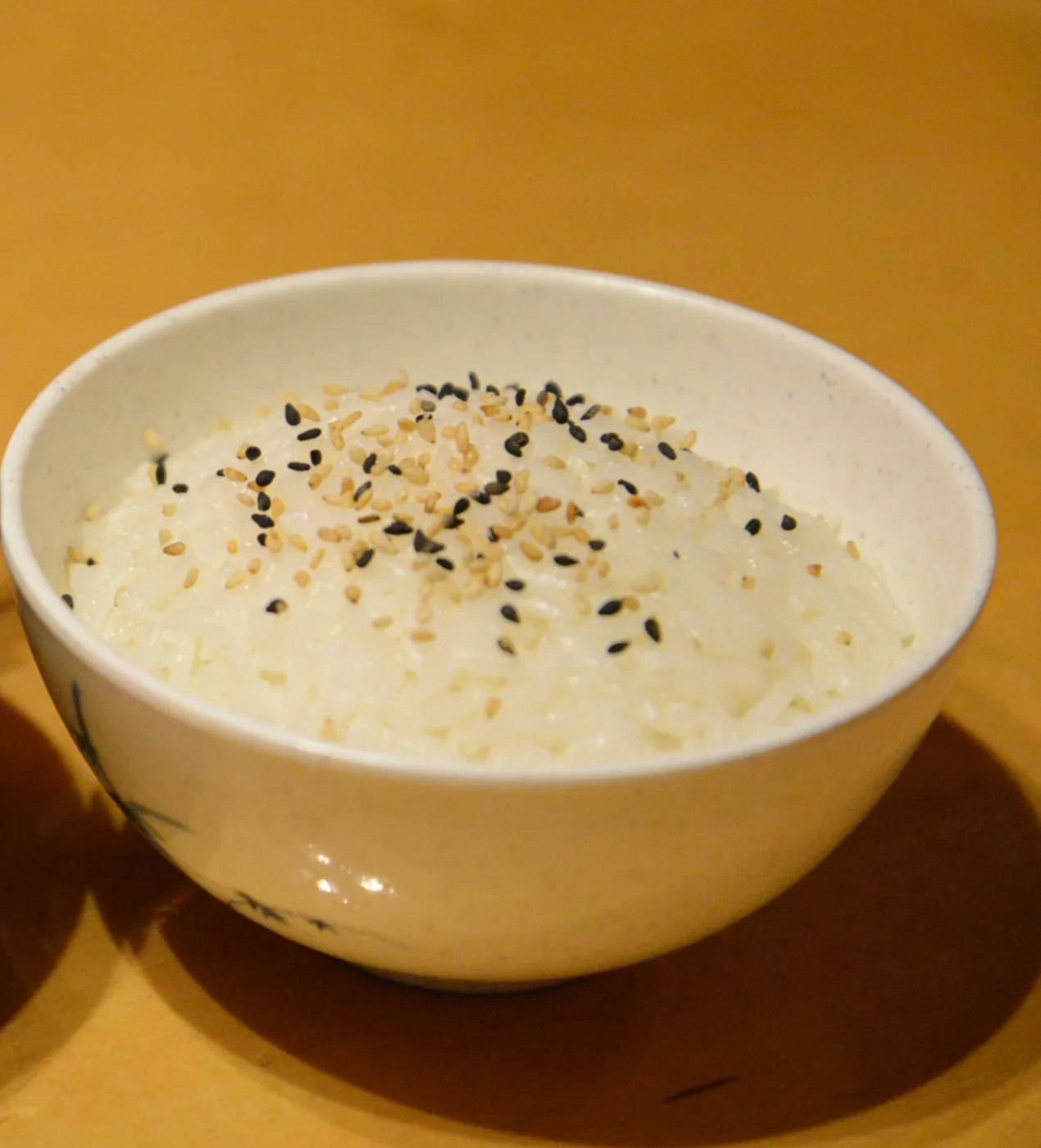 A bowl of steamed rice topped with sesame seeds