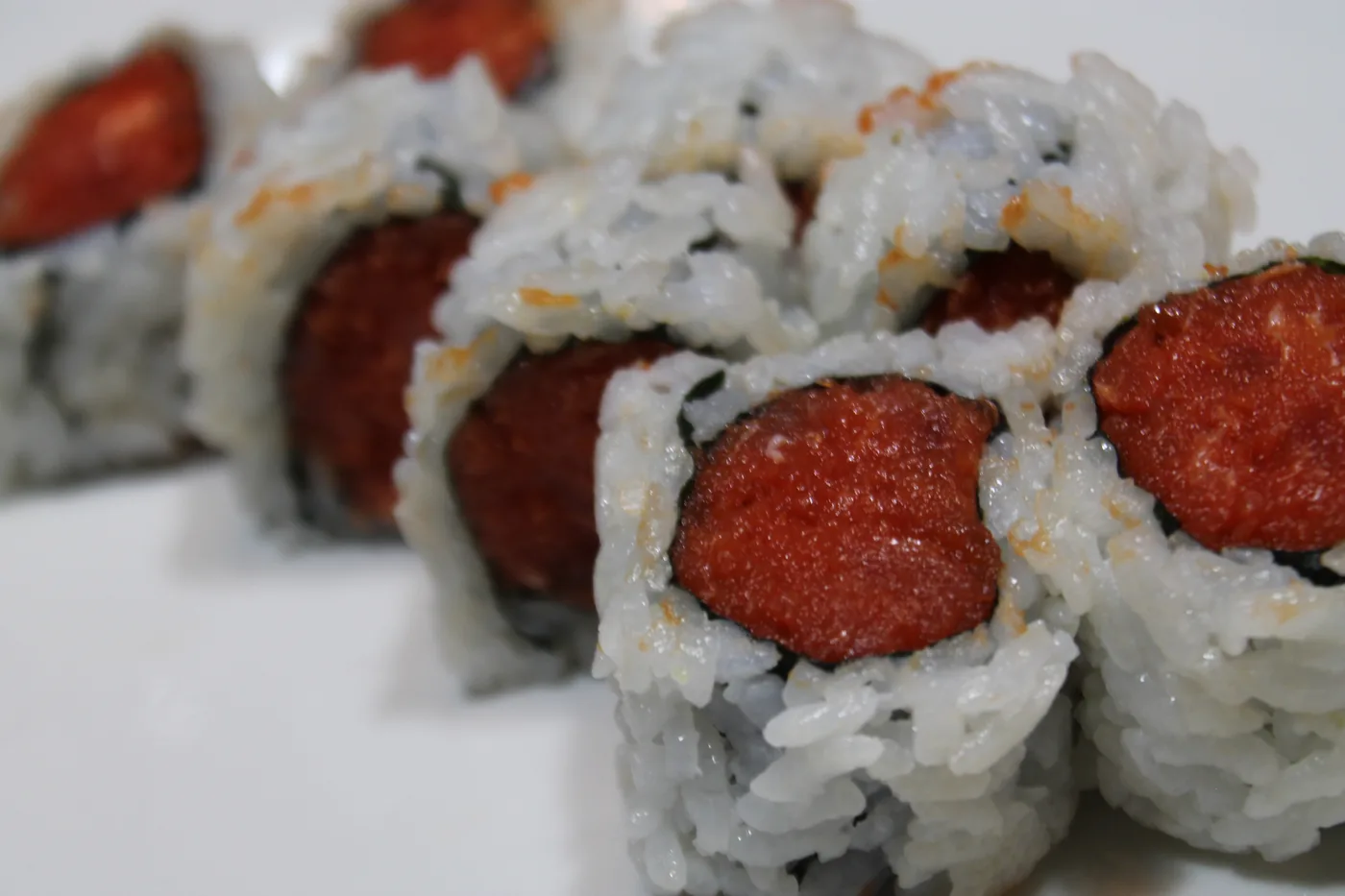 Spicy Tuna Roll cut into pieces, the filling visible in the centre