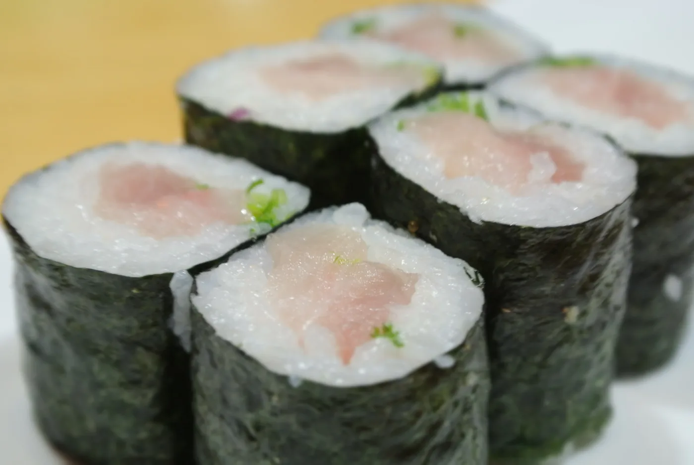 Yellowtail Roll cut into pieces with green onion in the centre