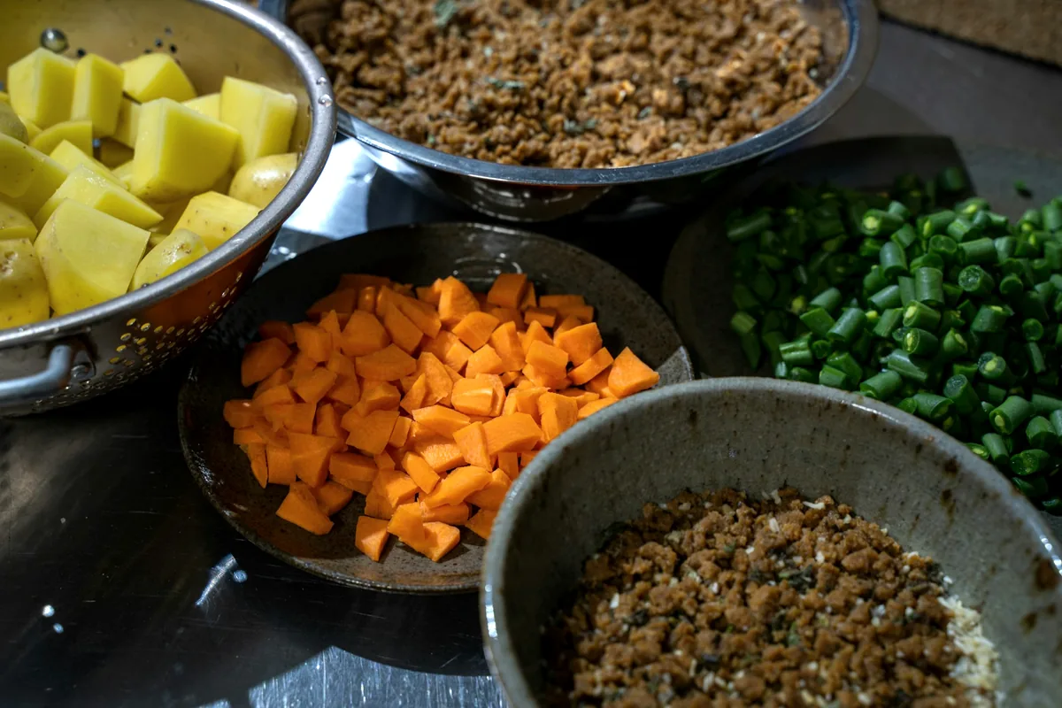 Small metal bowls of diced and chopped prepared toppings ready for service