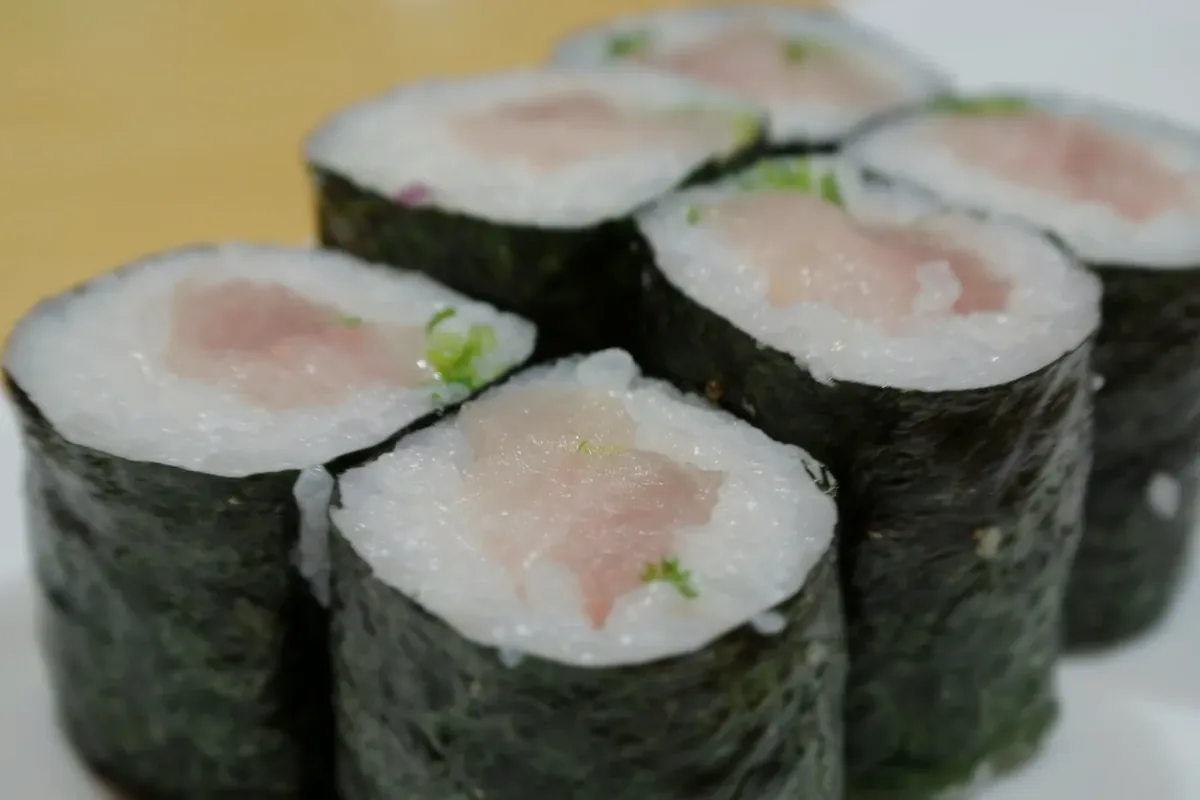 Yellowtail Roll cut into pieces with green onion visible in the centre